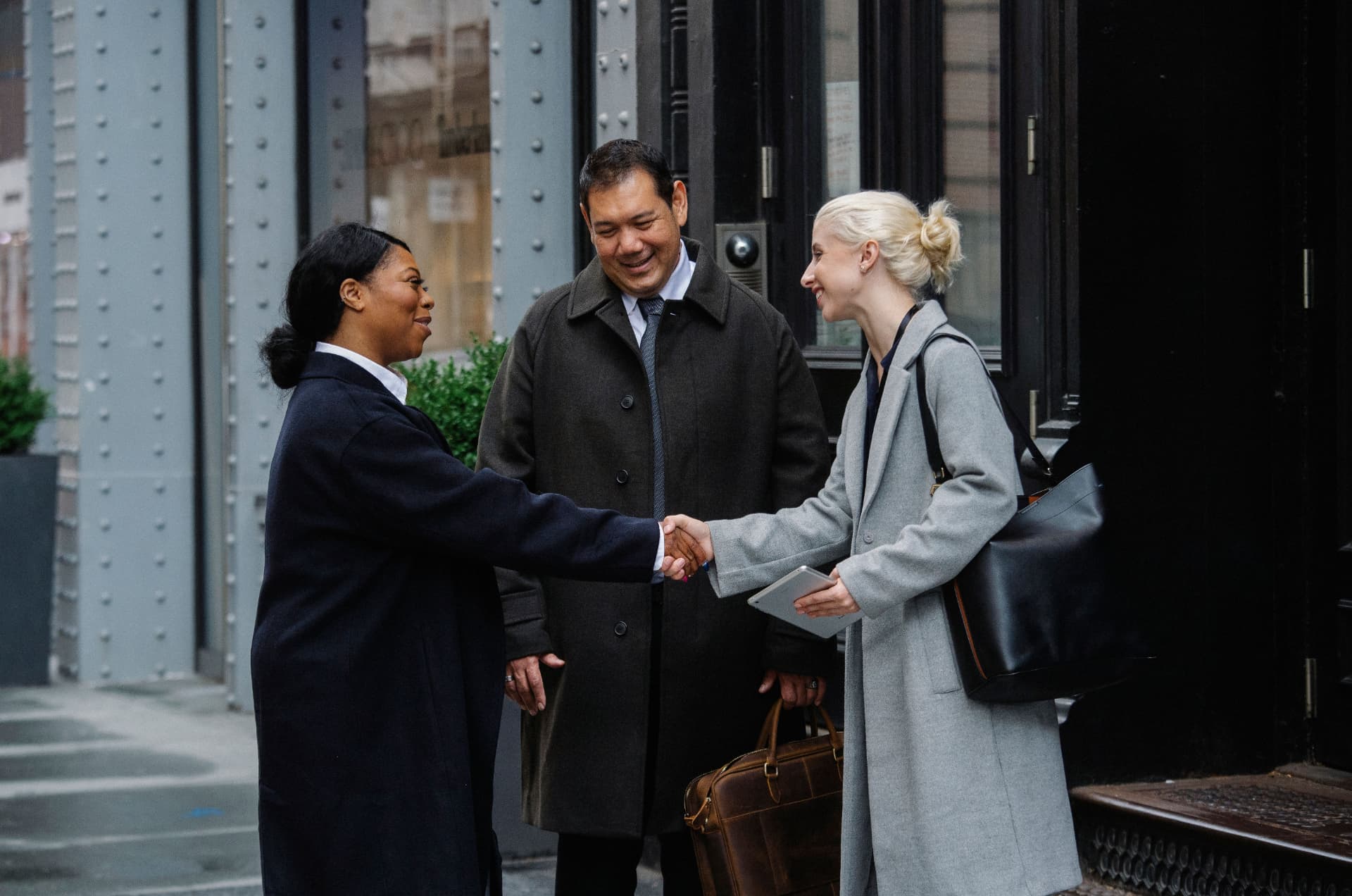 Professionals greeting each other outside an office
