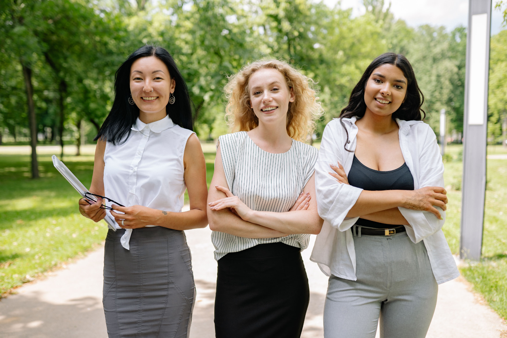 Three colleagues smiling together outdoors